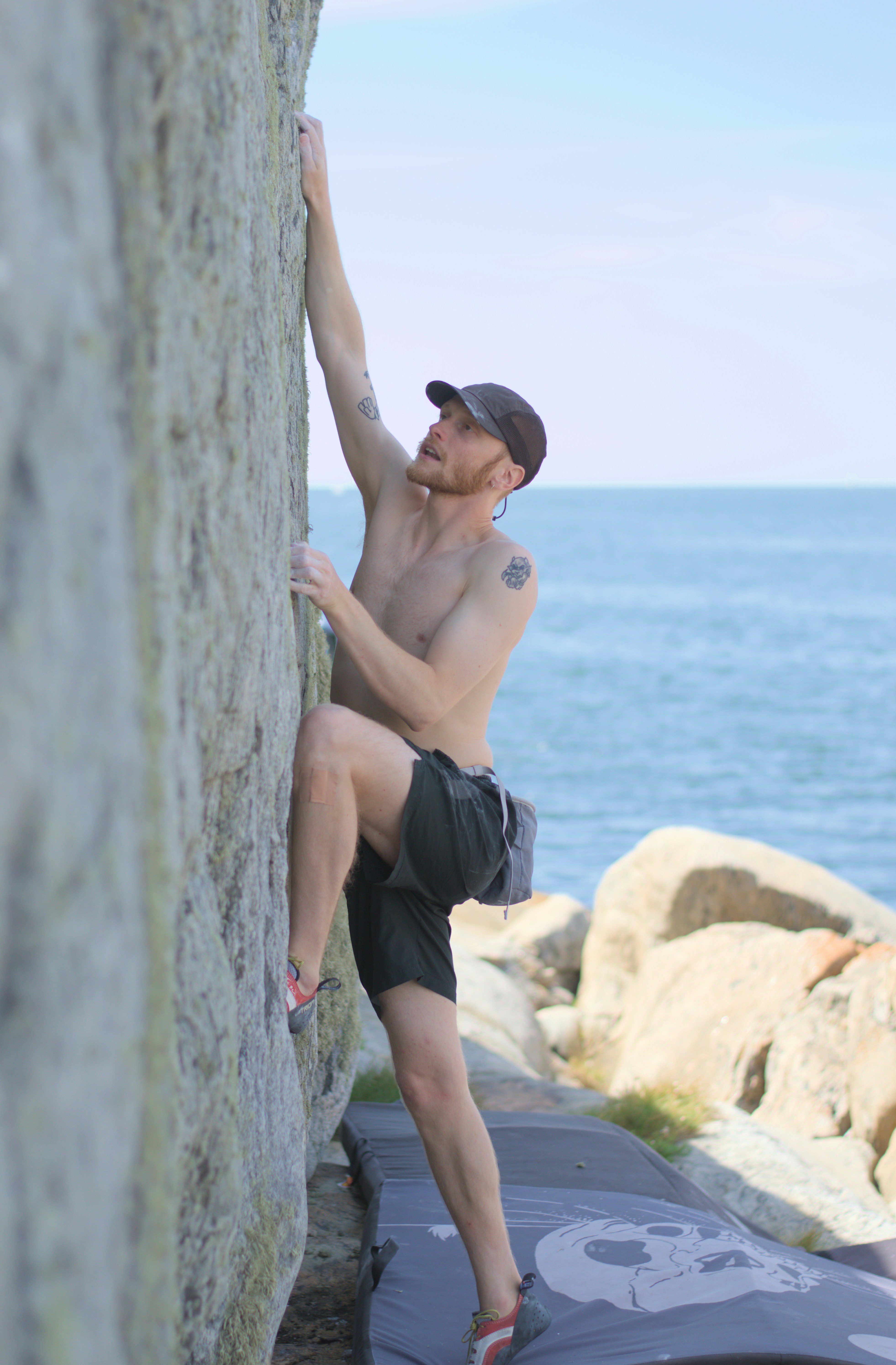 Rock climber scaling a cliff by the sea.