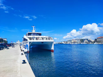 A ferry is docked on a sunny waterfront.