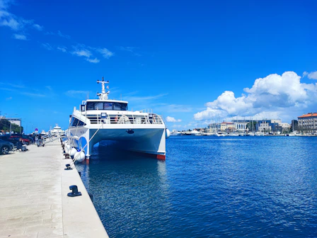 A ferry is docked on a sunny waterfront.
