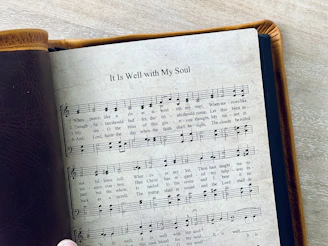 A leather-bound book displays hymn "it is well."