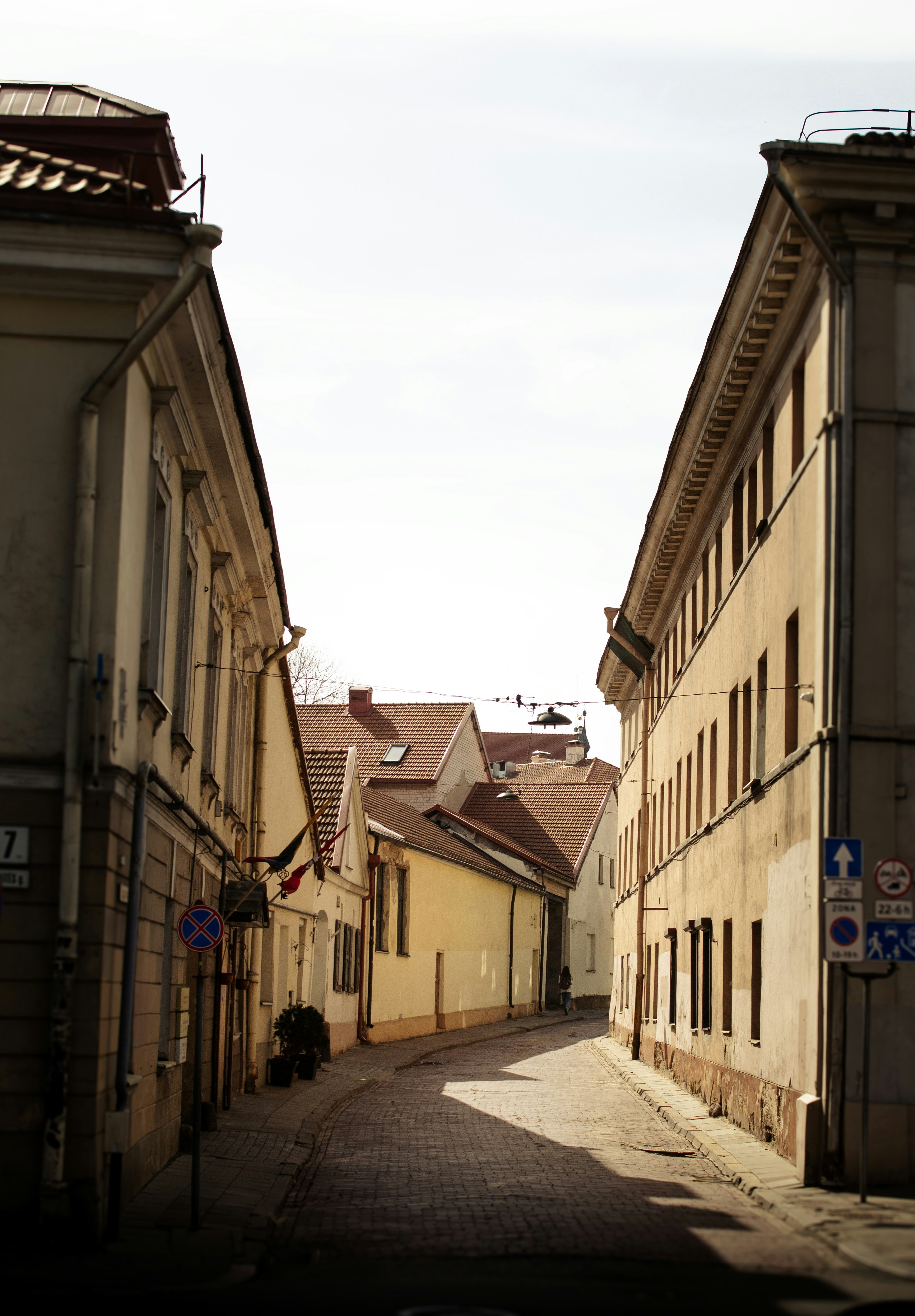 A narrow street is lined by buildings.