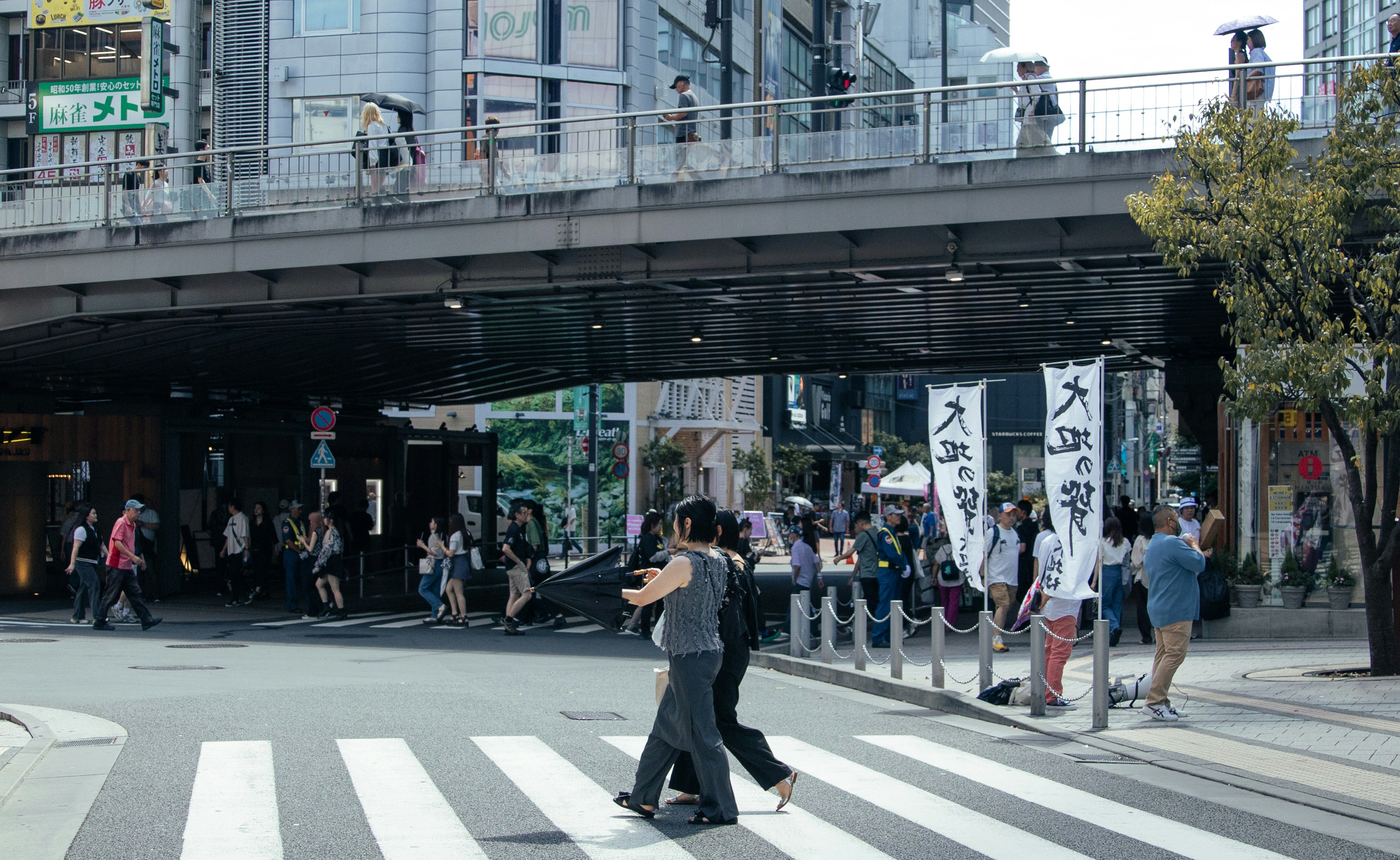 Group of tourists gathering at a bus stop in Shinjuku with ski bags and a tour company flag