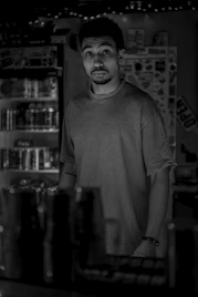 A man gazes forward inside a dark store.