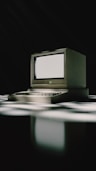 A vintage computer sits on a patterned surface.
