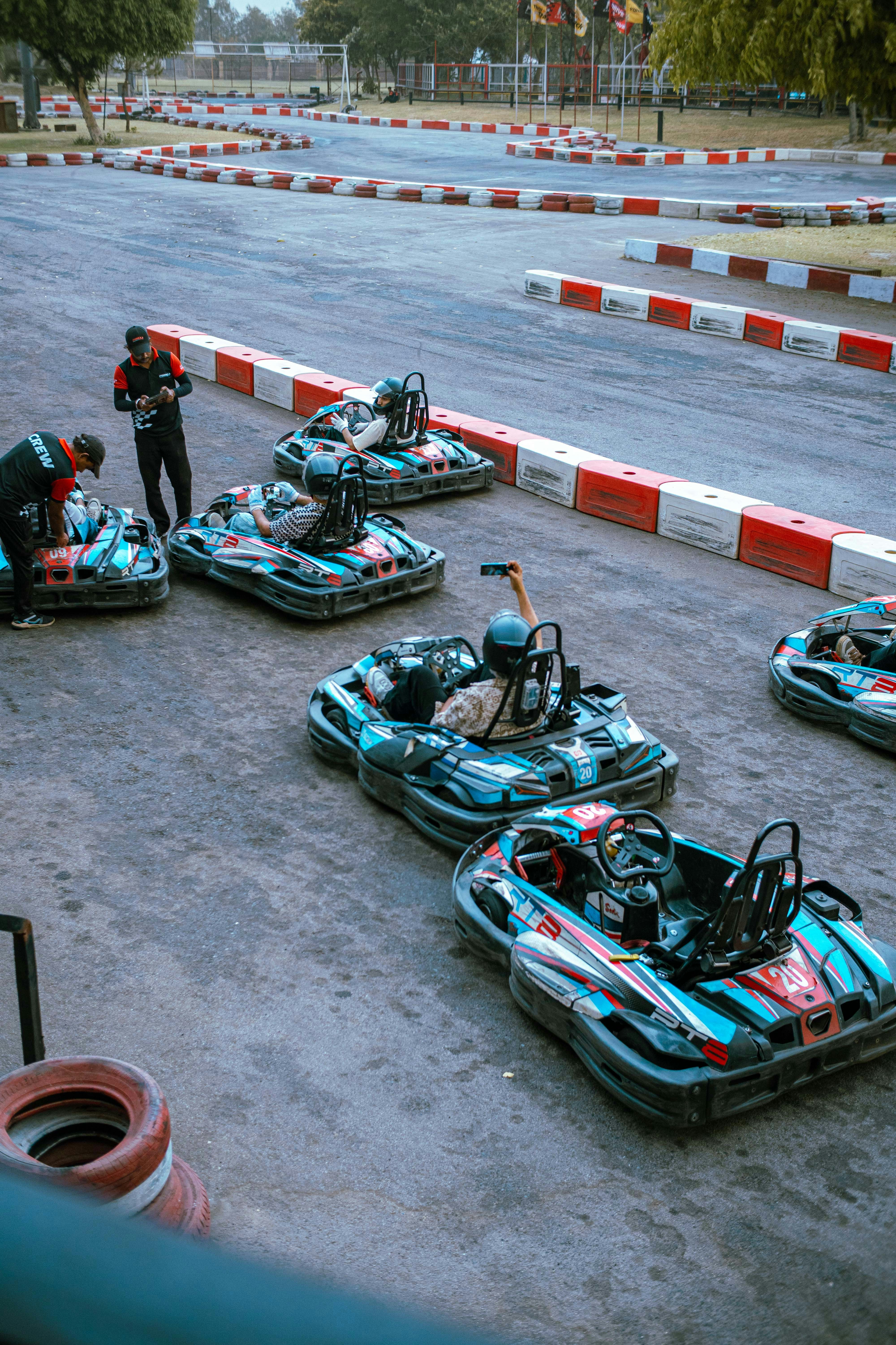 Go-karts are lined up on a race track.