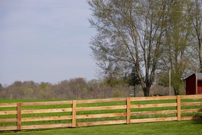 A wooden fence spans a green field.