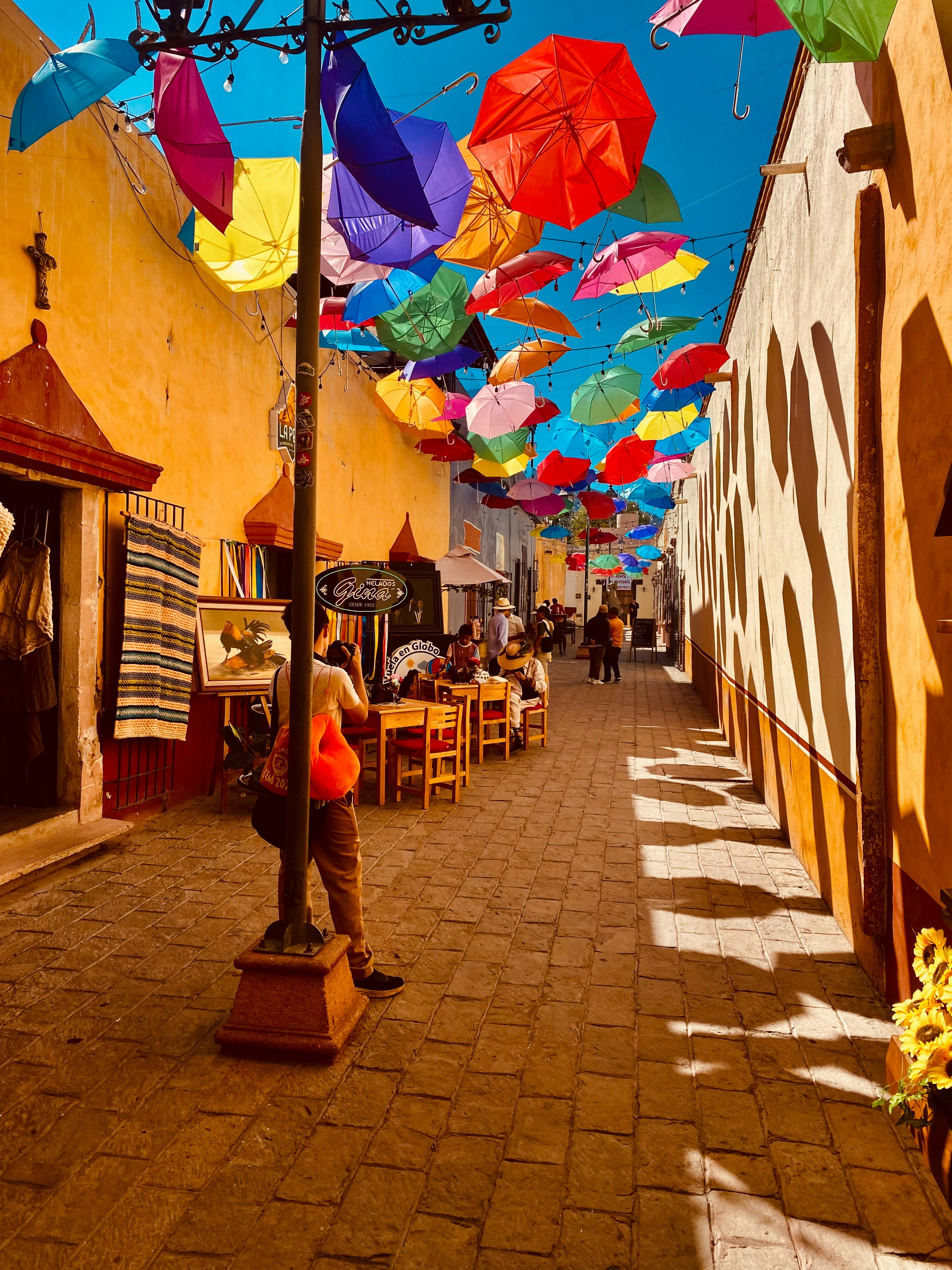 A colorful street is decorated with umbrellas.