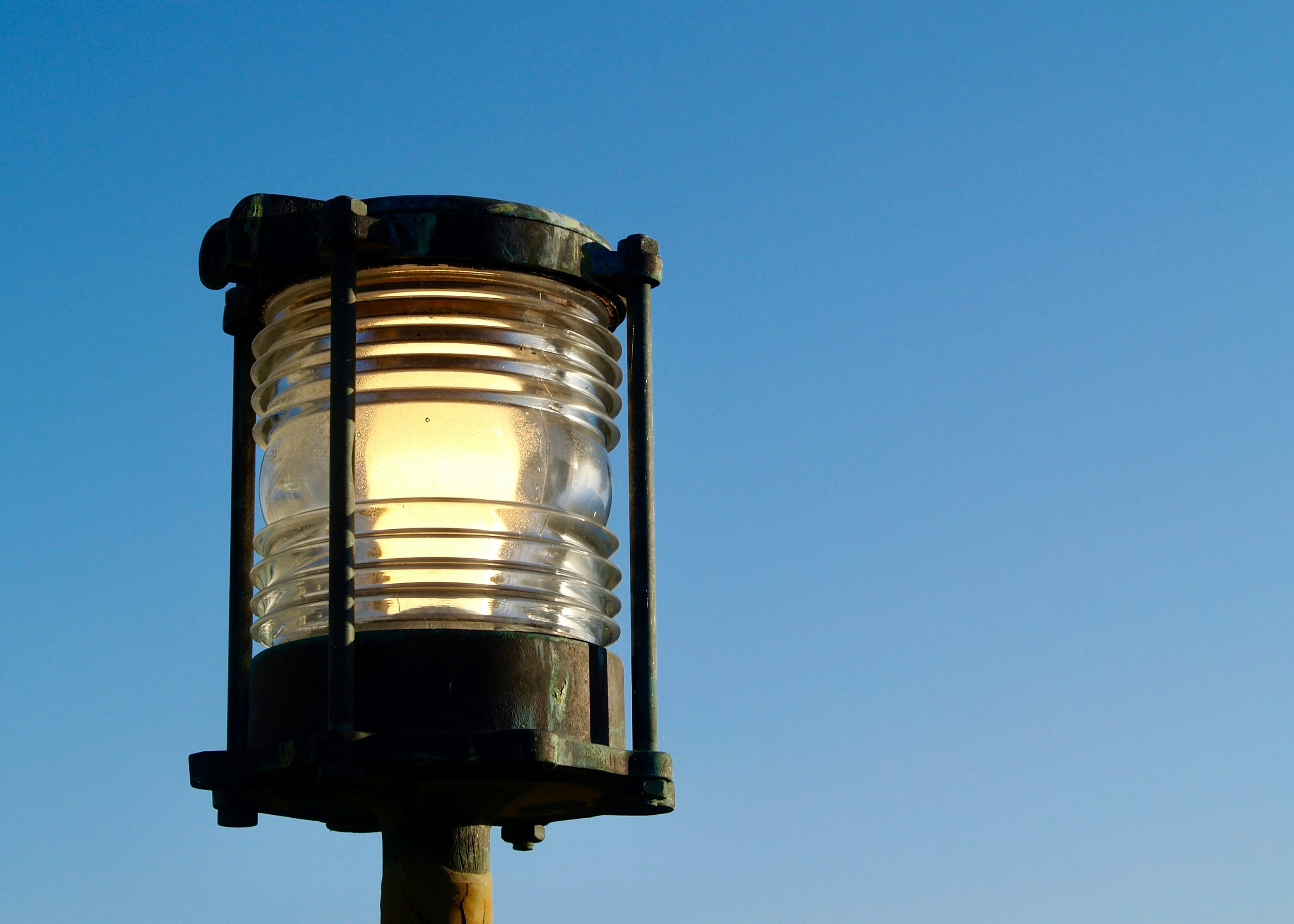 A lantern glows brightly against a blue sky.