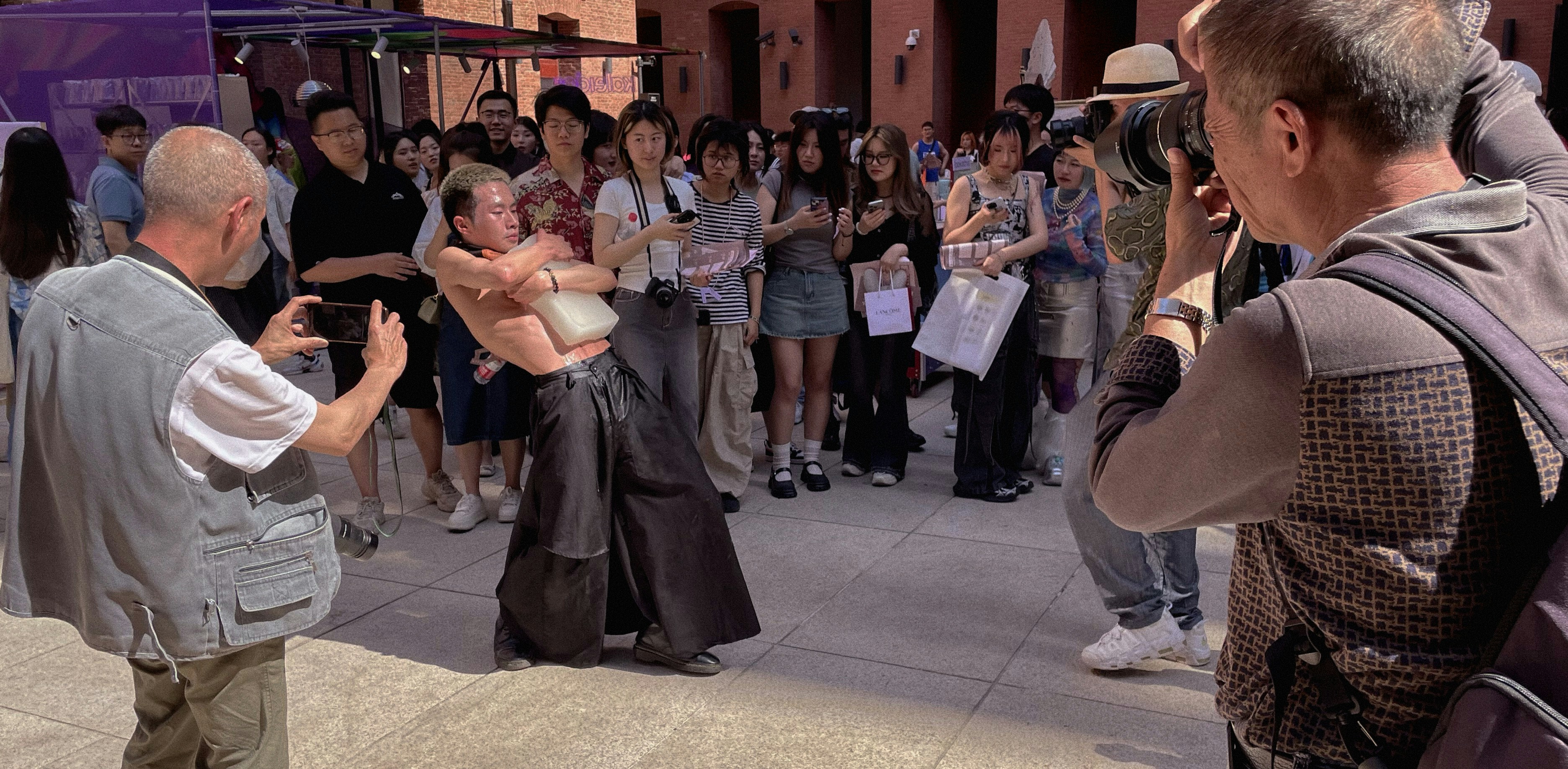 A Shanghai thoroughfare, Anfu Road mirrors humanity’s crave for attention—fame-seekers’ stage, tourists’ trophy, and a hotbed of street photography. Lenses prowl daily, turning bodies into “content,” until a woman’s “No Trump, no right to shoot me!” shatters the illusion on live TV, unmasking the predatory gaze behind “art.” Jia Di, a local photographer, likens the road to a false utopia: “Here, ‘friendship’ means strangers chasing validation, boundaries dissolving under ‘artistic freedom.’” The paradox? Love someone? Save them from its curated kindness; hate them? Let its shallow “community”