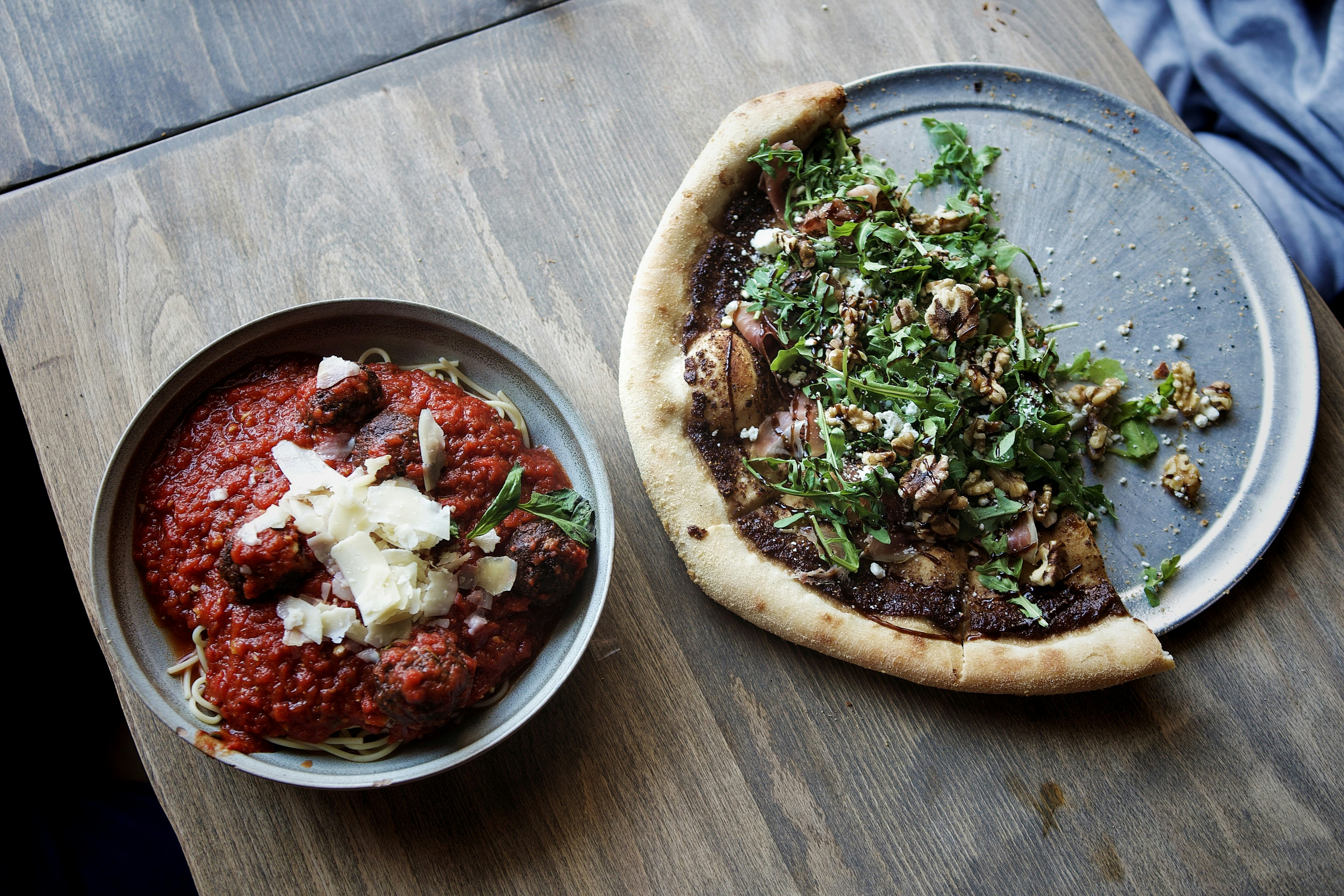 Pizza and spaghetti sit side-by-side.