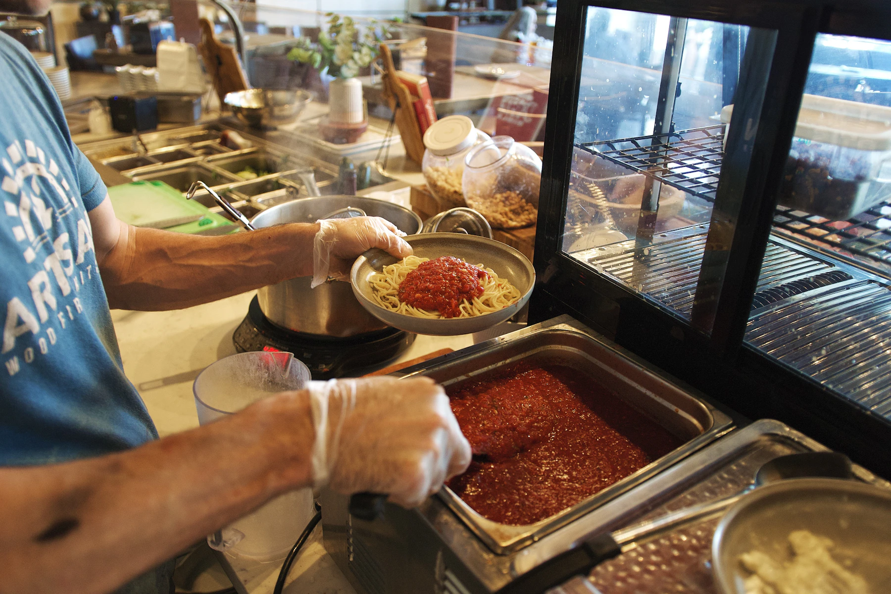 A cook preparing pasta in a restaurant kitchen — Brad / Unsplash