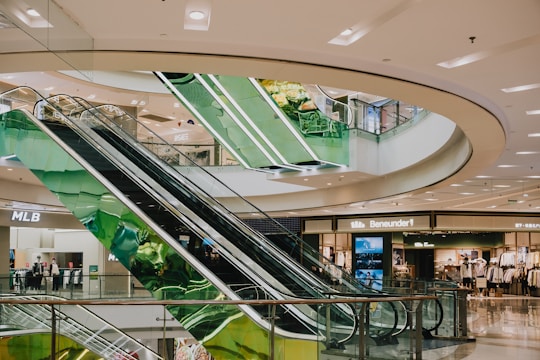 A multi-level shopping mall with escalators.