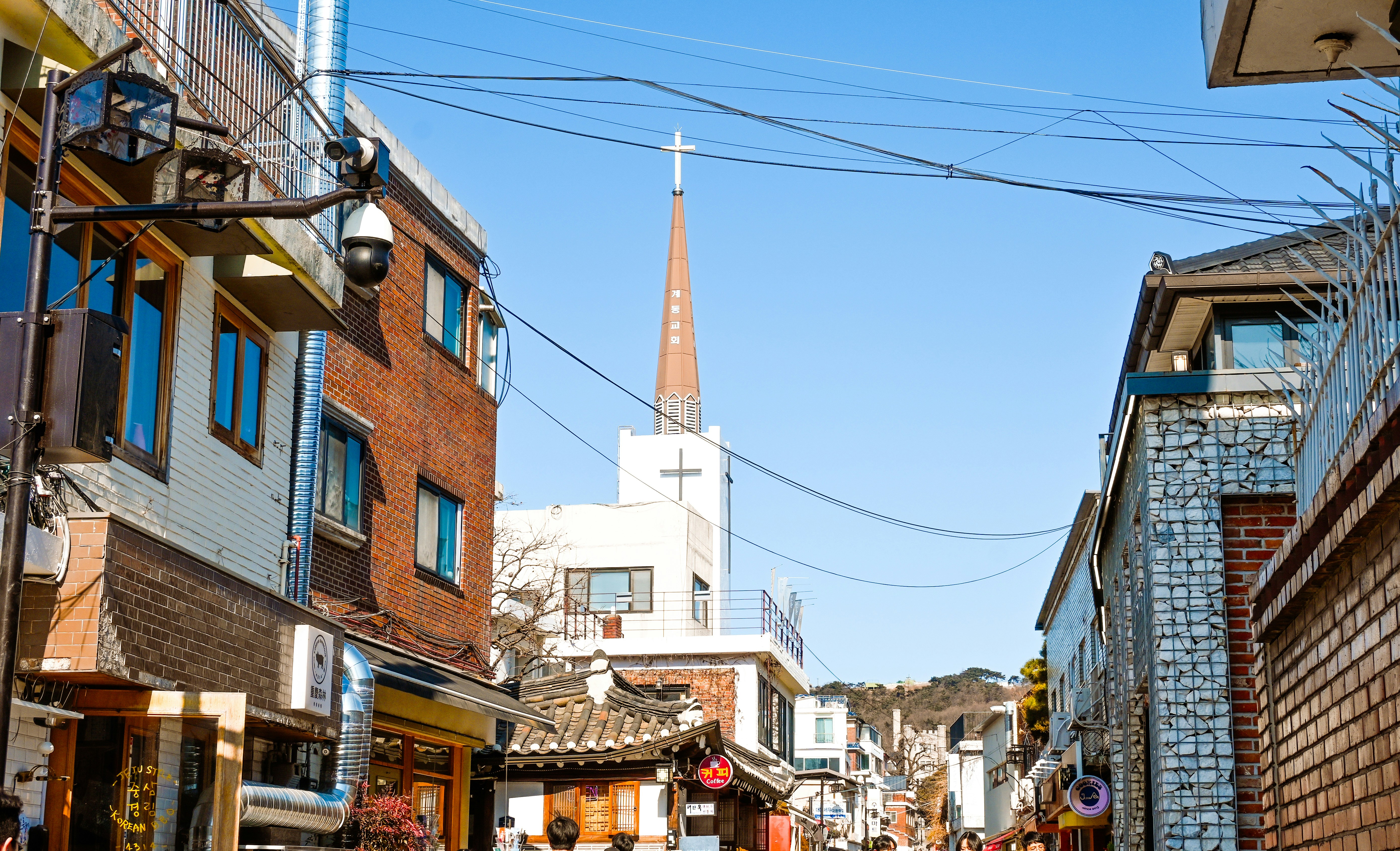 A narrow street with a church in the distance.