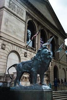 A lion statue stands in front of a building.