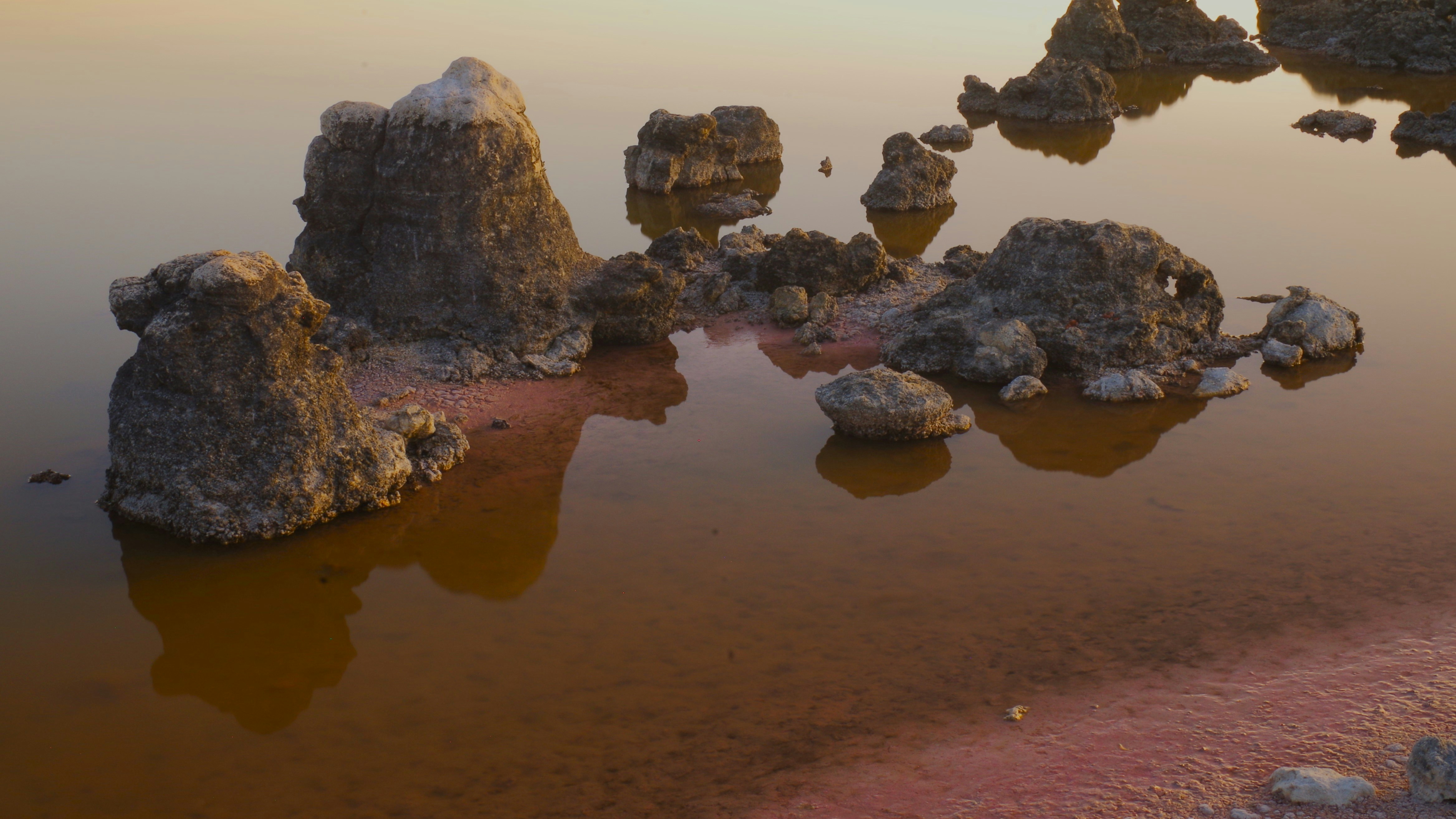 岩場は赤みを帯びた水に反射します。