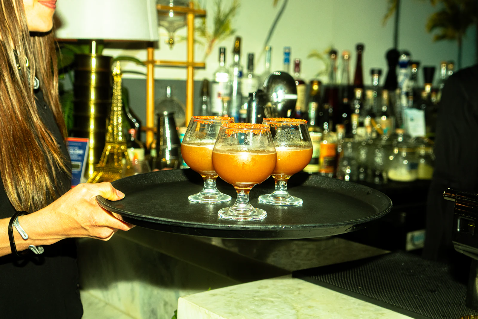 Waitress carrying a tray of cocktails through the lounge
