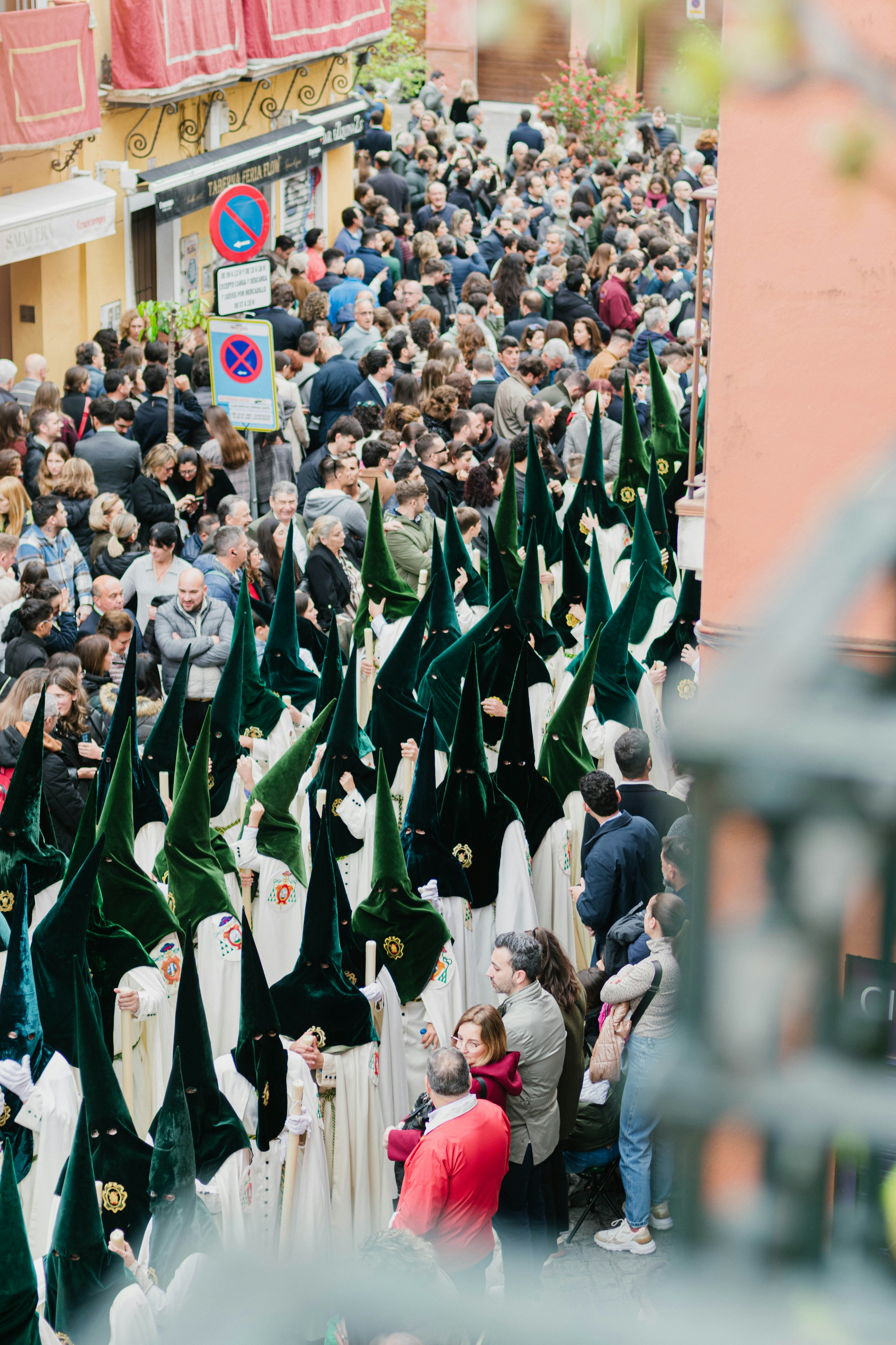 A procession walks through a crowded street.