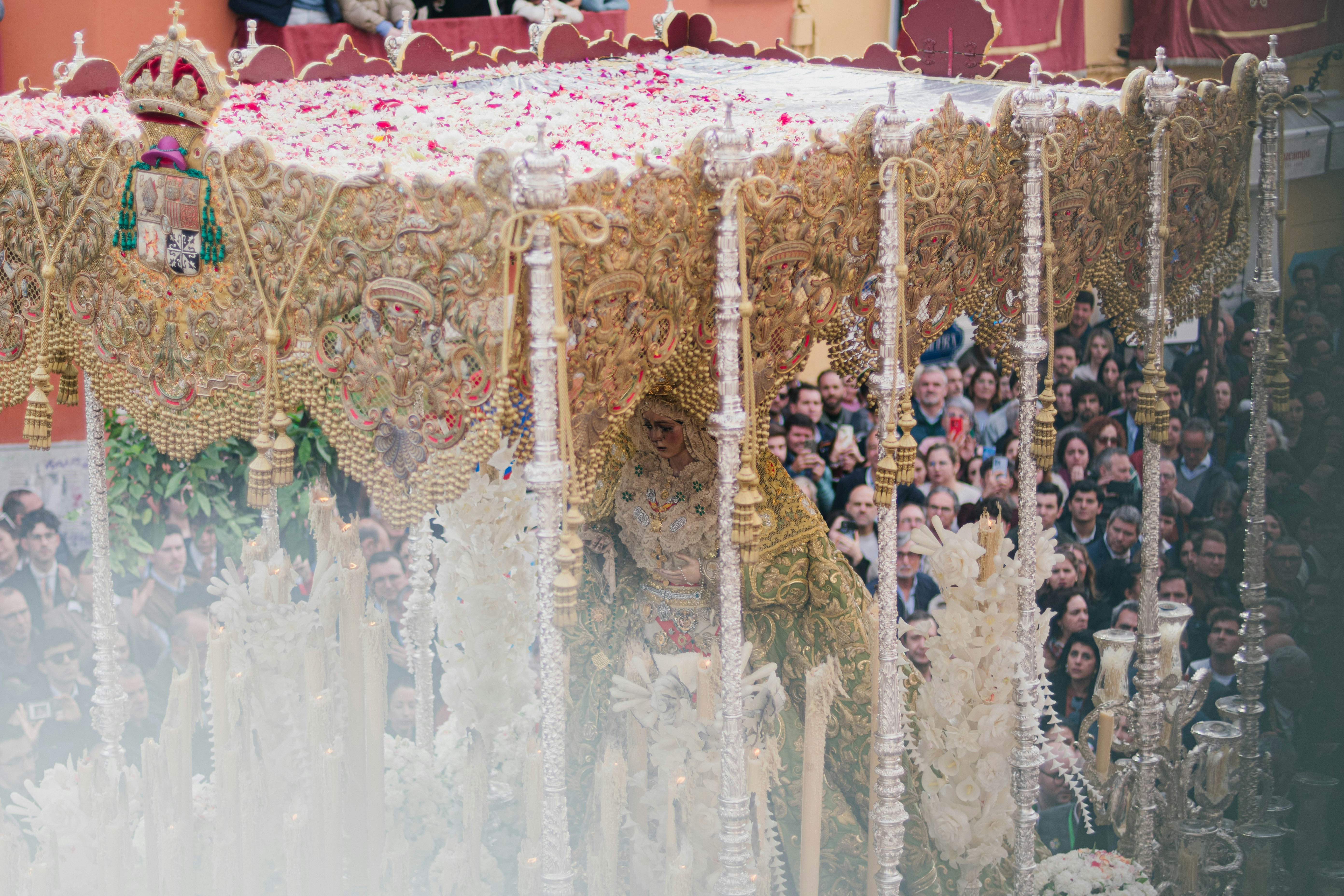 A religious procession with people watching.