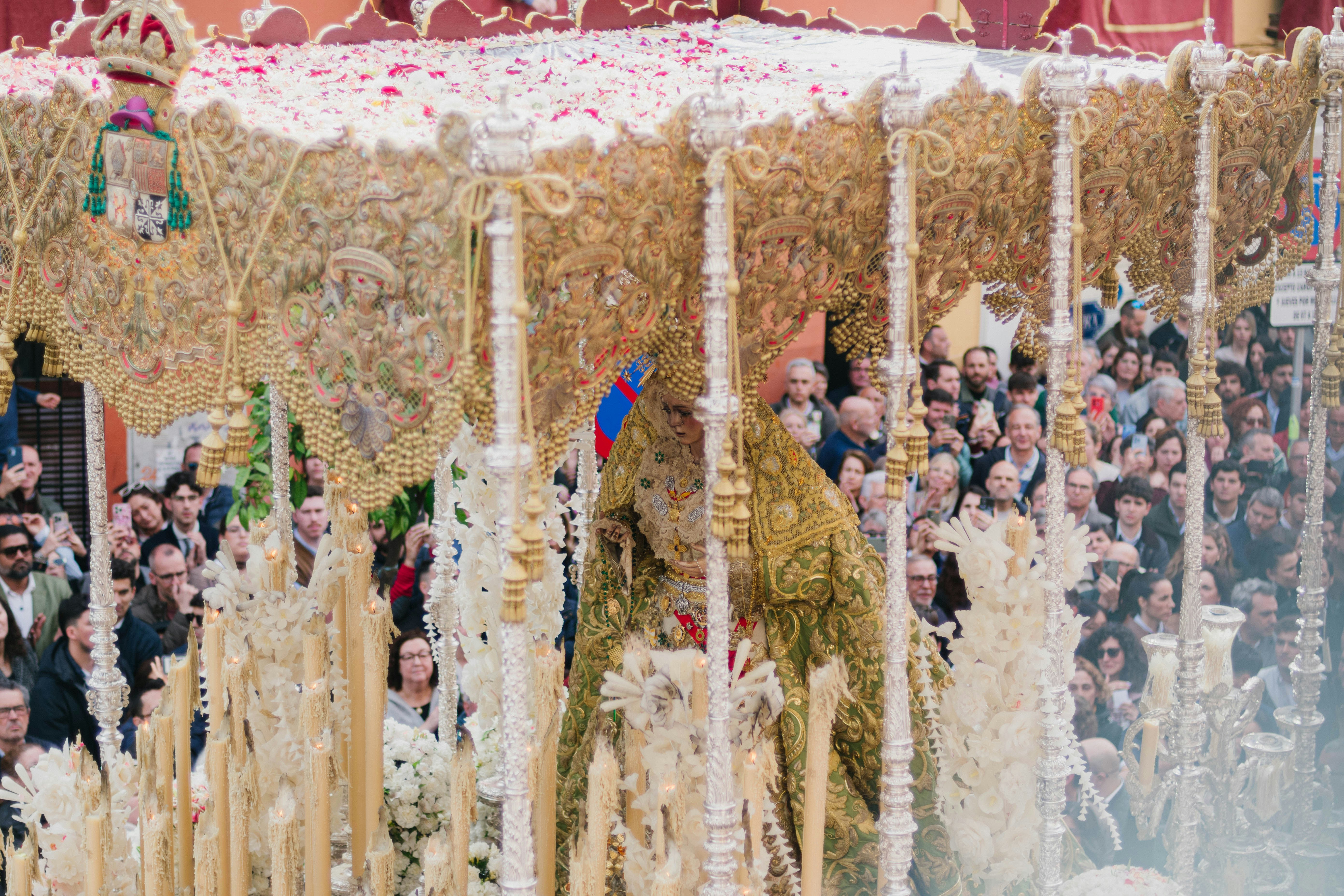 A religious procession is happening with onlookers.
