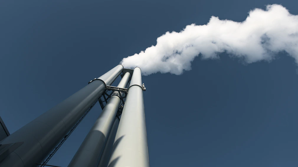 Smoke billows from industrial chimneys into the sky.
