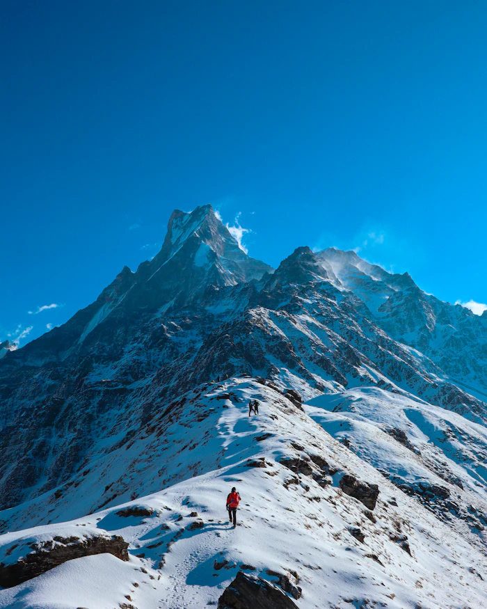 Trekkers crossing a snowy ridge