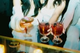 People are holding up cocktails in a close-up shot.