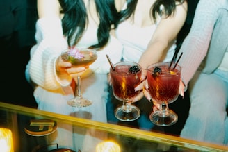 People are holding up cocktails in a close-up shot.