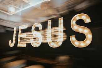 The word "jesus" illuminated in bright lights.