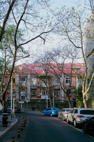Cars parked on a street in front of a building.