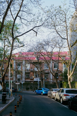 Cars parked on a street in front of a building.
