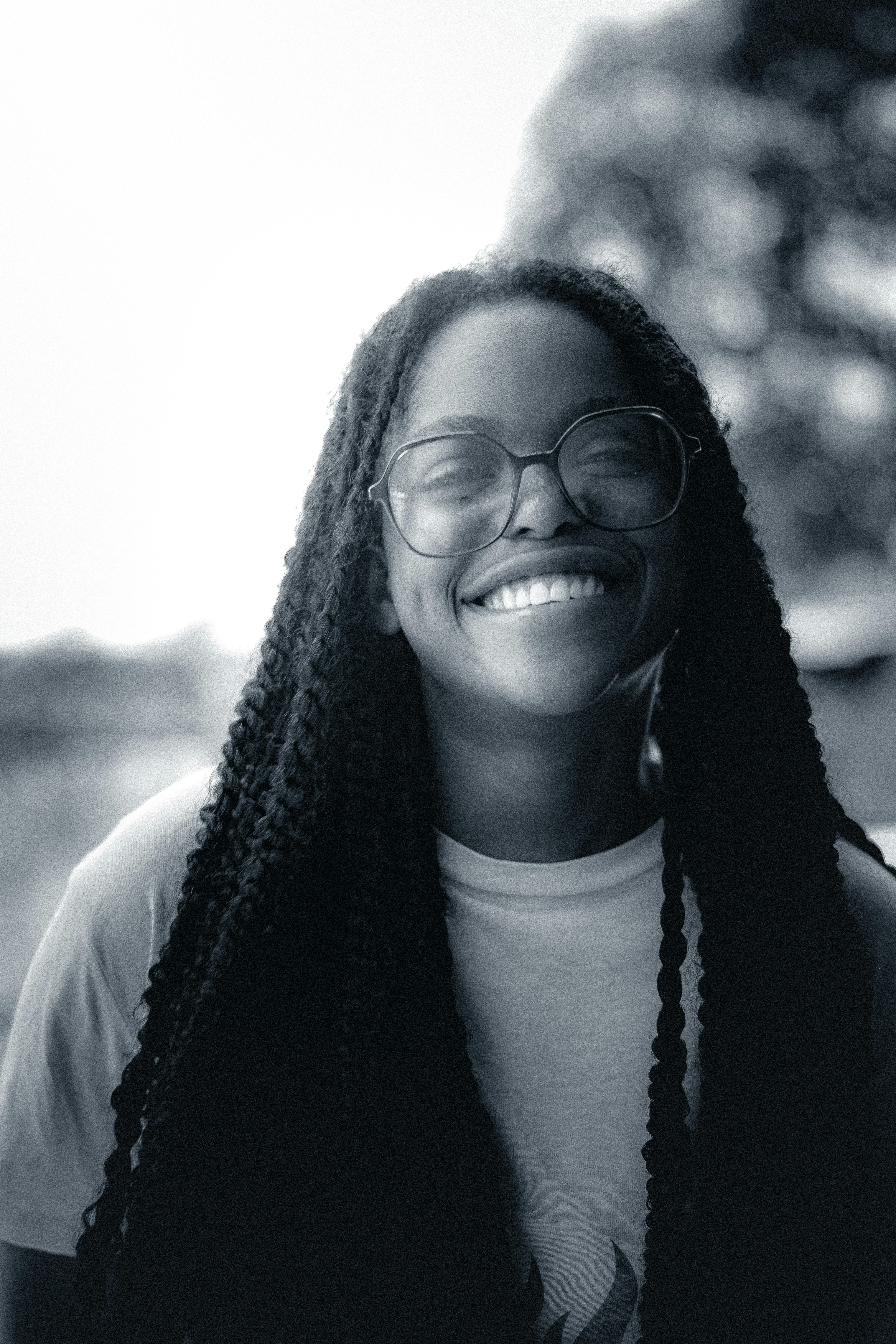 Smiling woman with glasses and long braids.