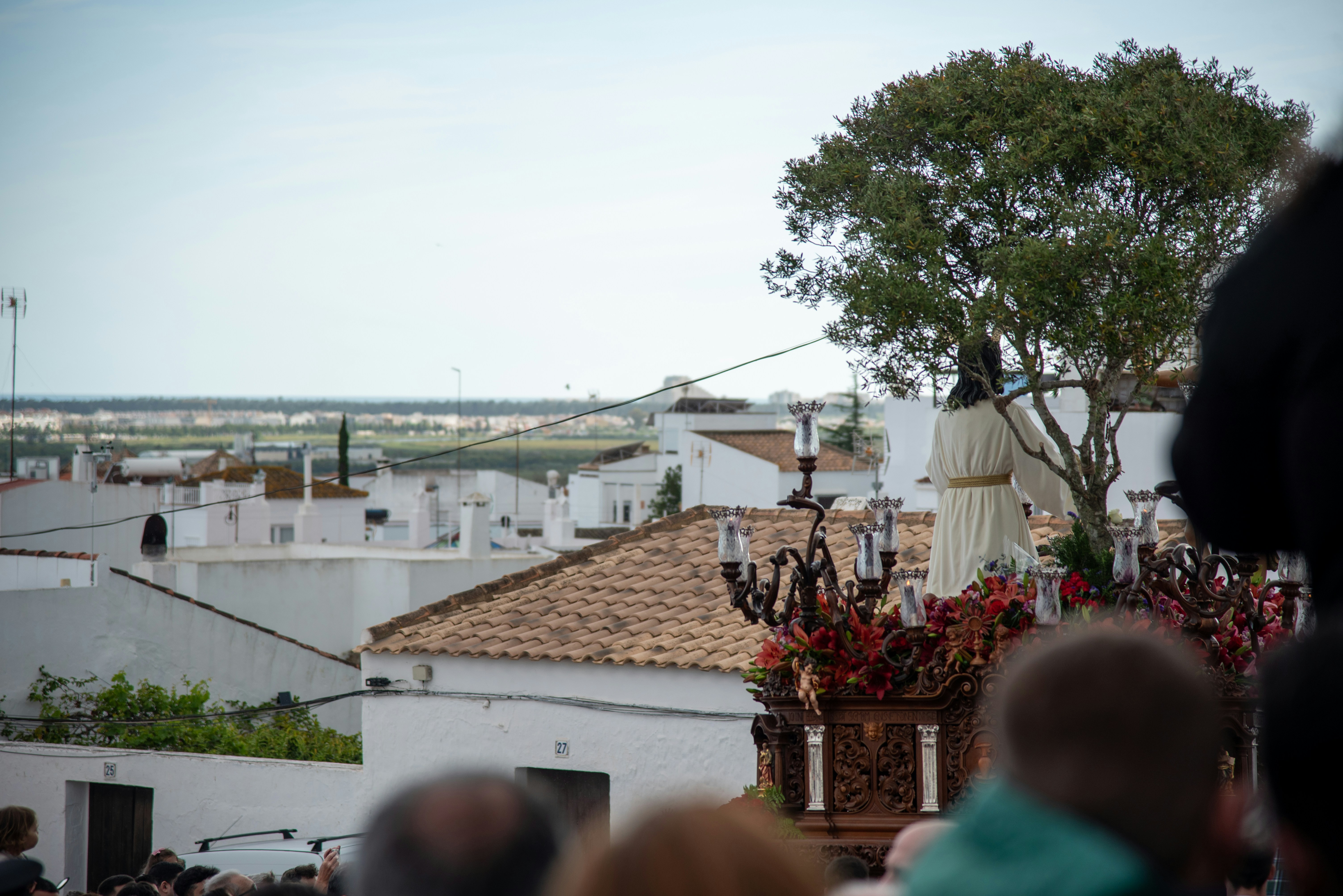 A procession carries a statue through a town.