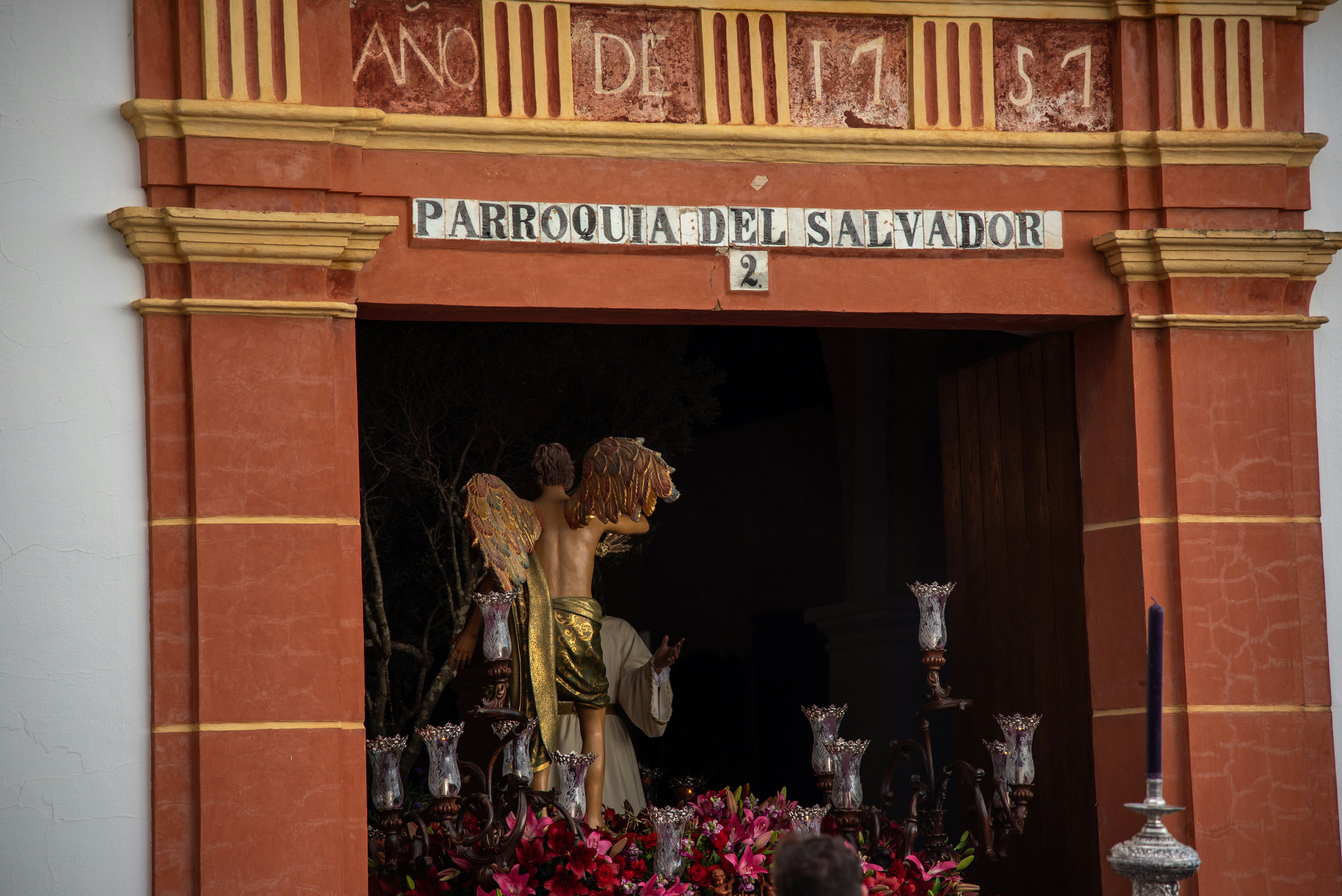 A statue is seen through an arched doorway.