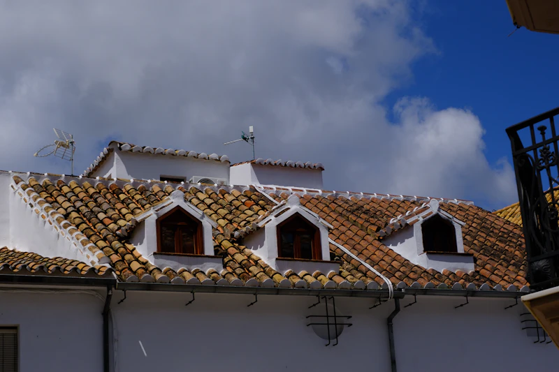 Residential rooftops beneath stormy skies—hail and wind damage assessments