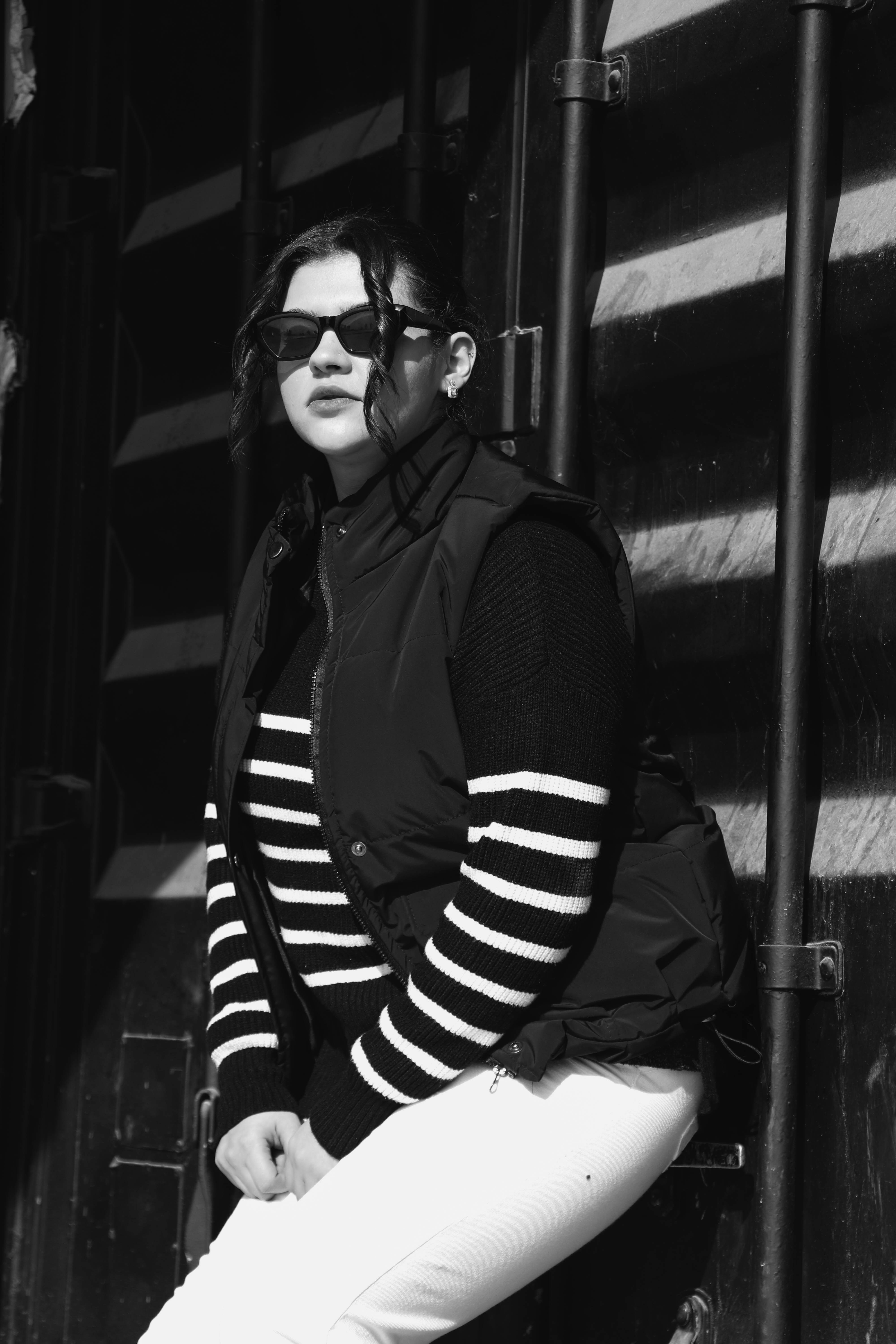 Woman posing in front of a dark wall.