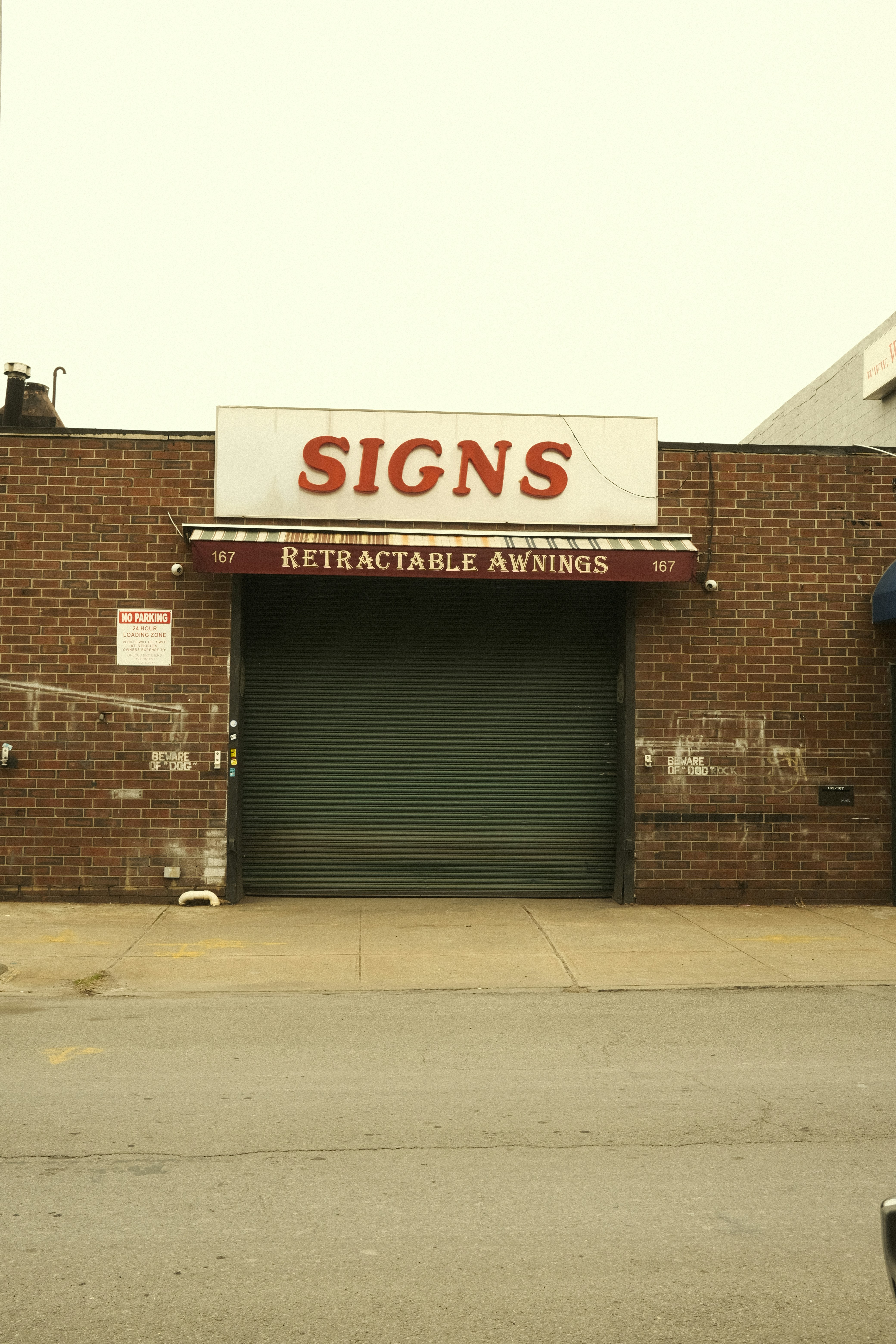 The sign reads "signs" above a closed garage door.