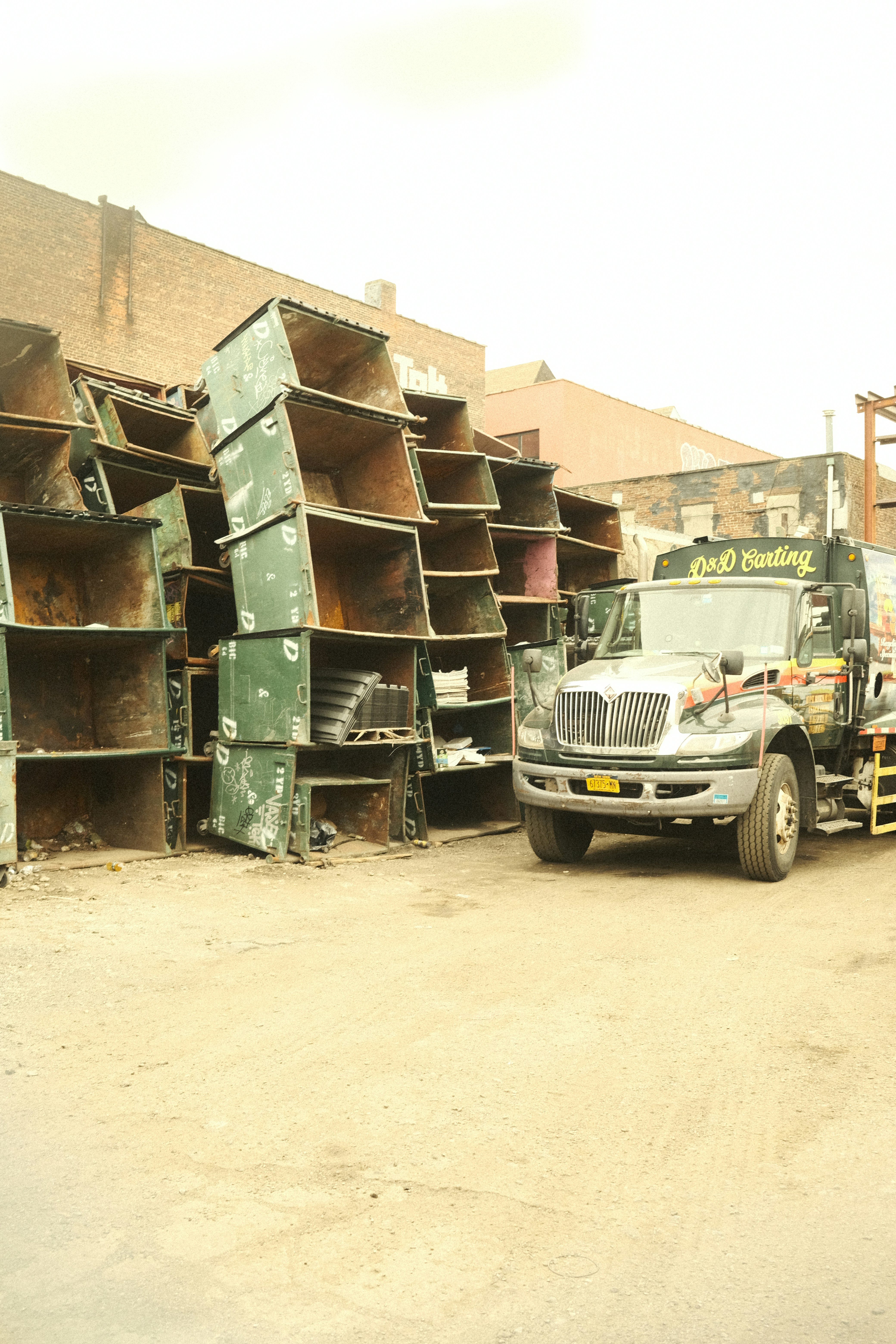A truck parked near a pile of large metal bins.