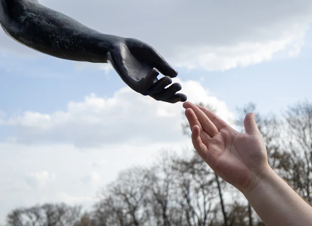 Two hands reaching out, almost touching