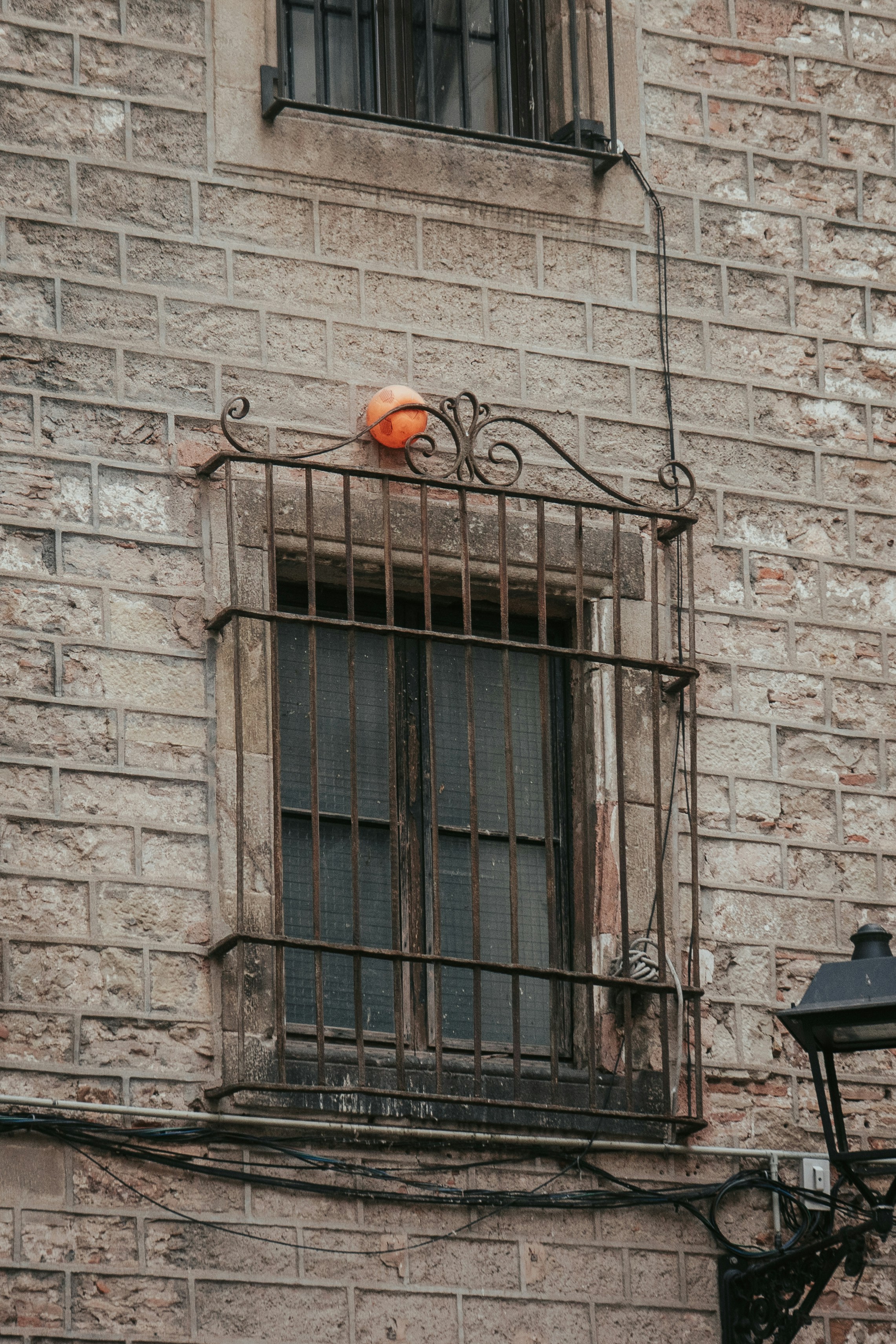 A grated window on a brick building.