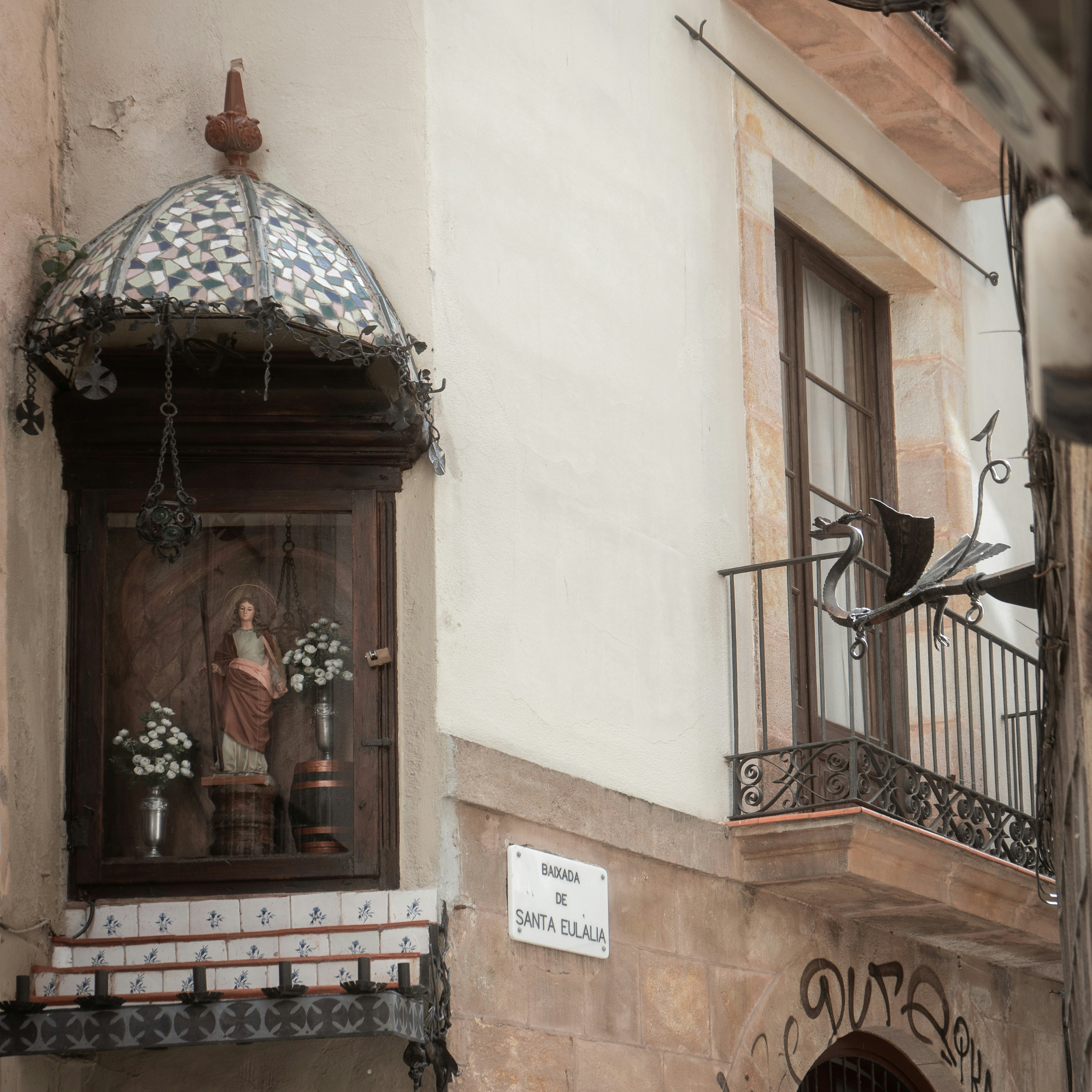 An ornate religious niche is on a building's facade.
