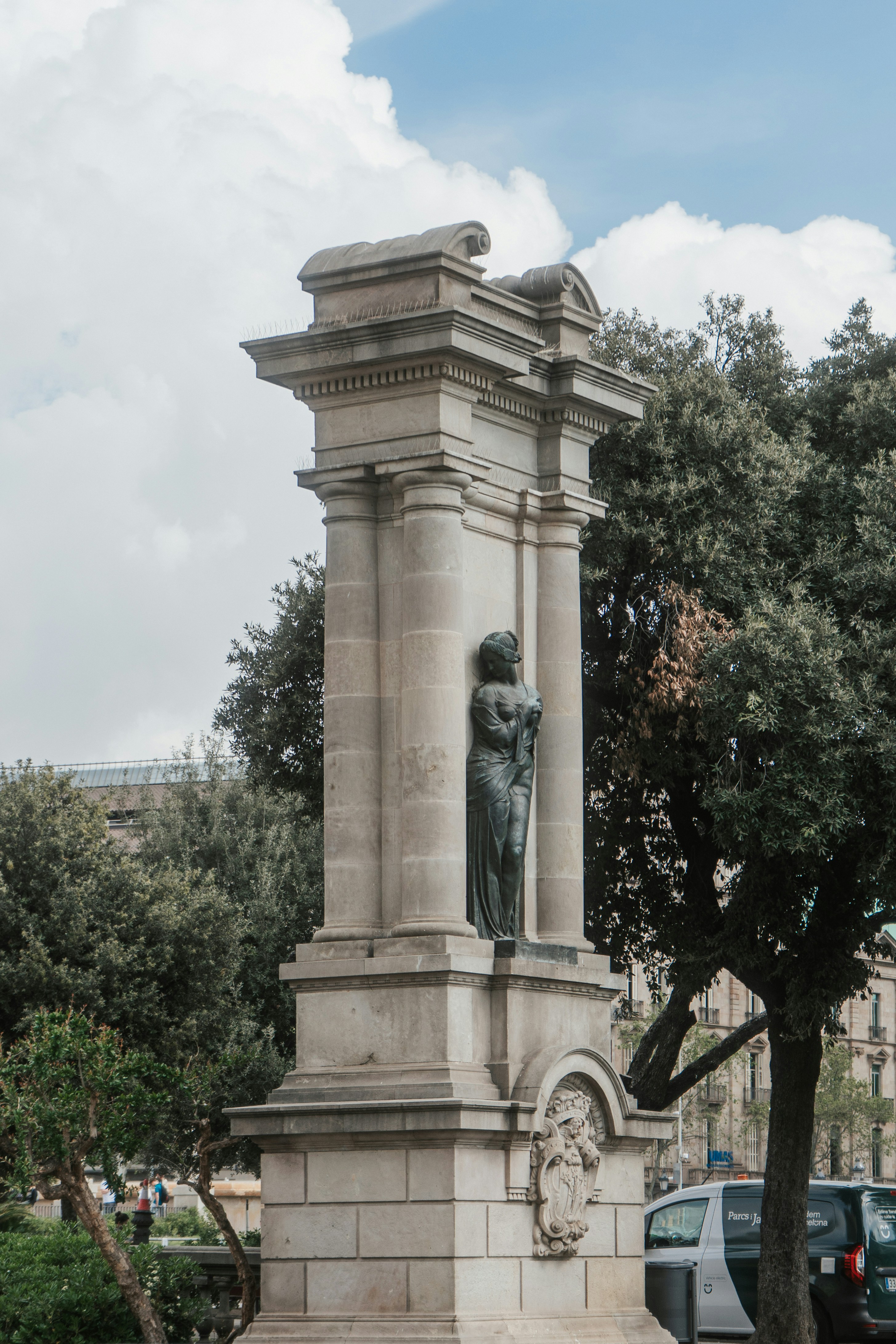 A statue stands within a classical stone column.