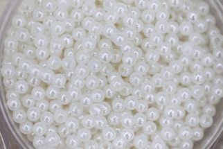 Many small, white pearls are shown in a close up.