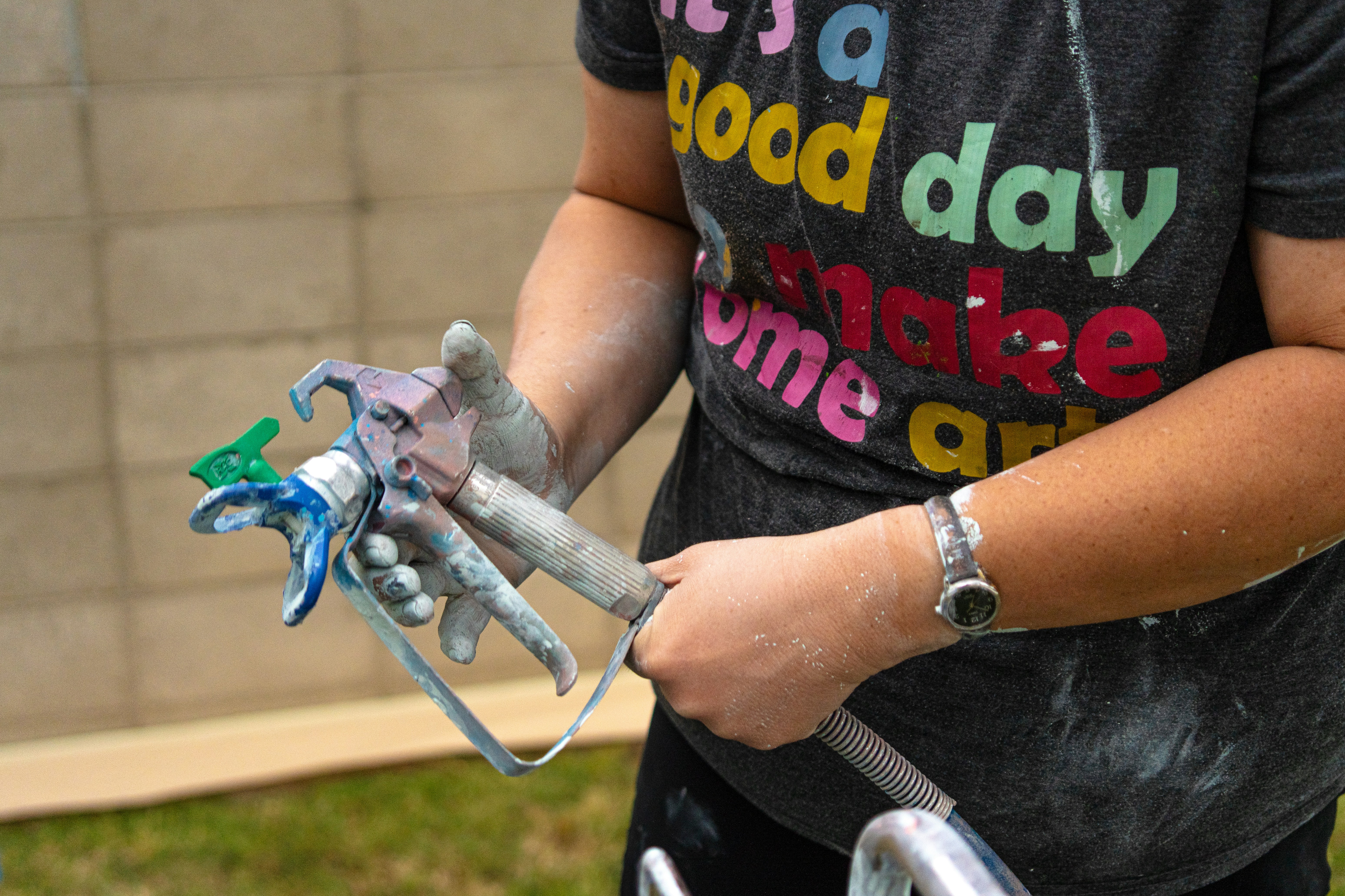 A person holds a paint sprayer.