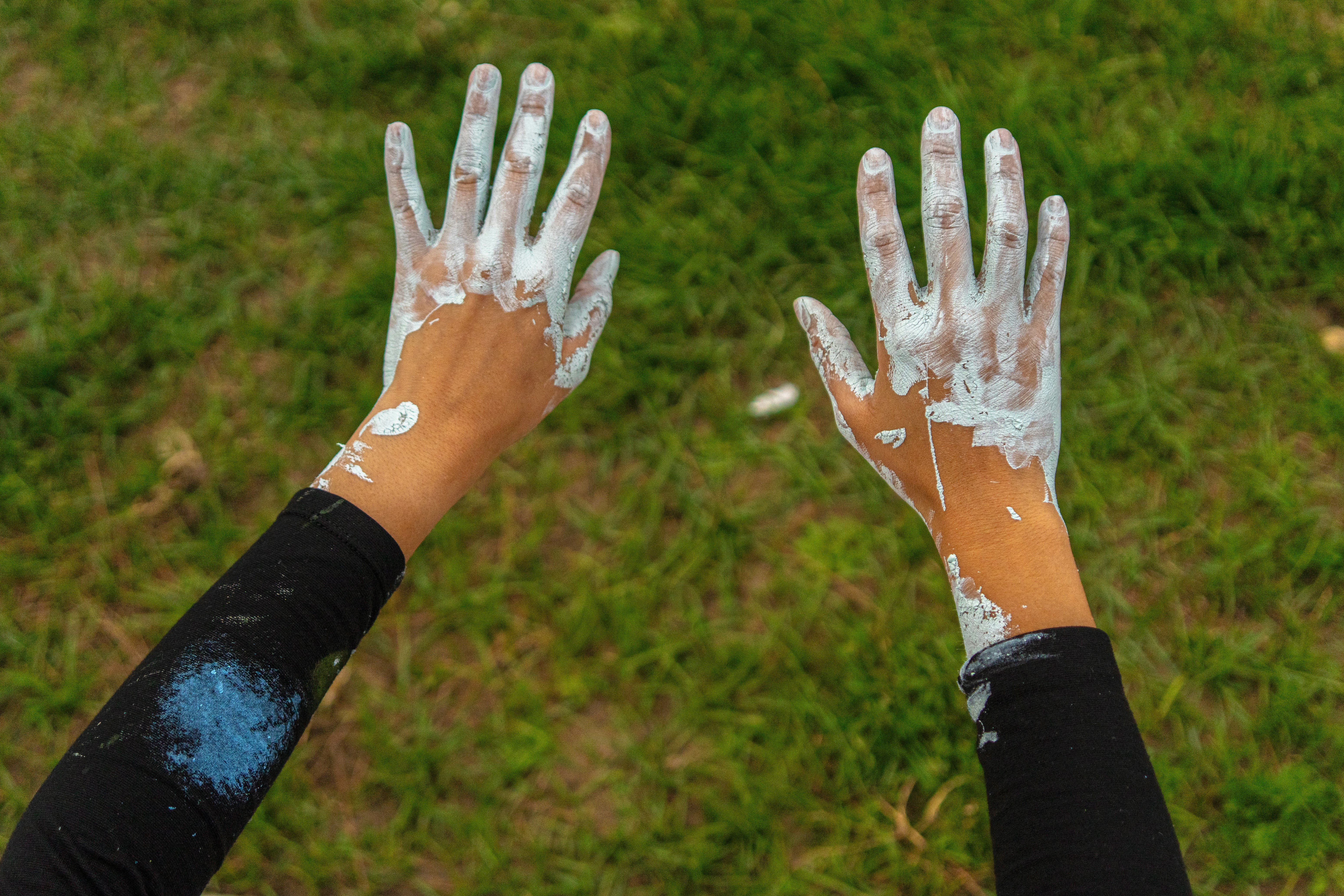 Hands are covered in white paint.
