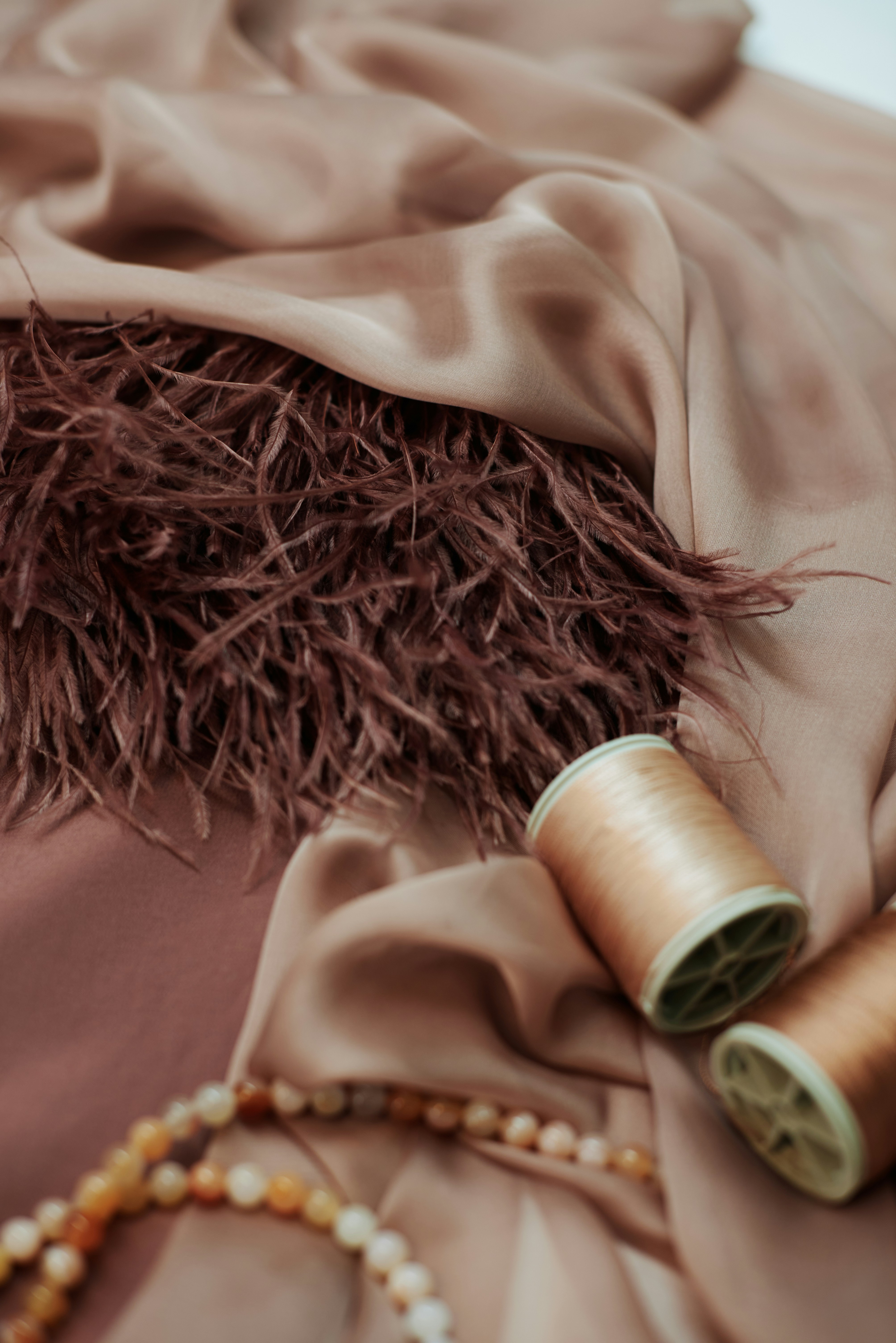 Fabric, feathers, beads, and thread create an elegant display.