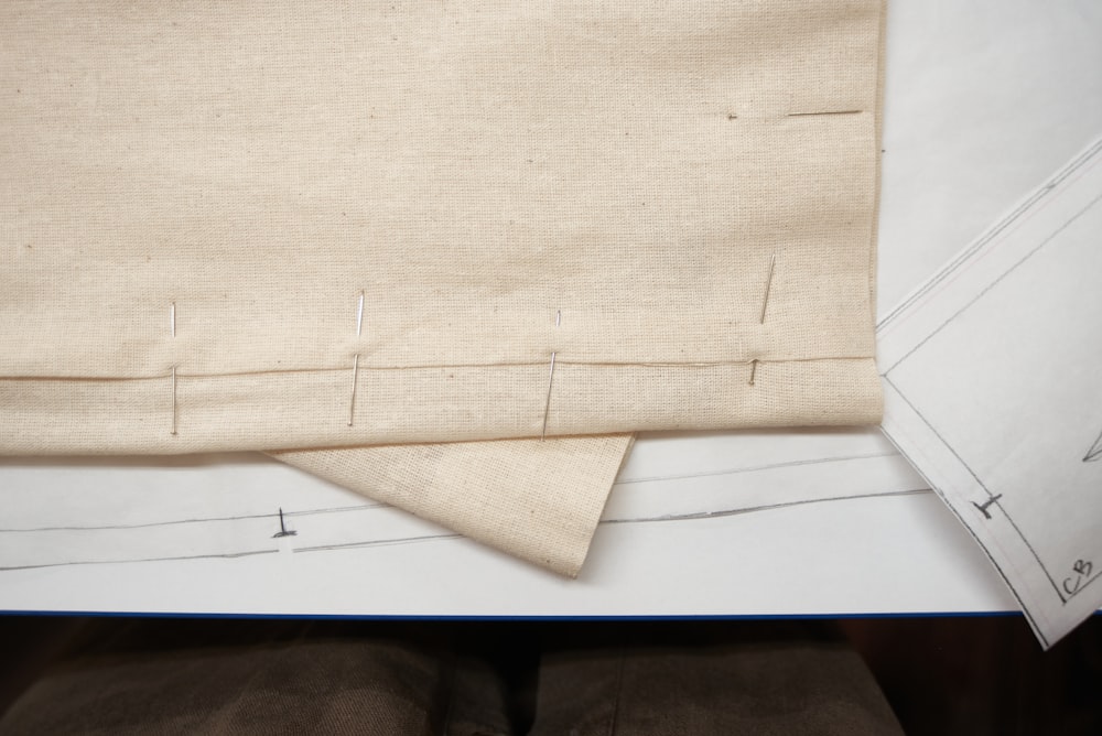 Cloth pinned over a paper pattern while an atelier piece is developed