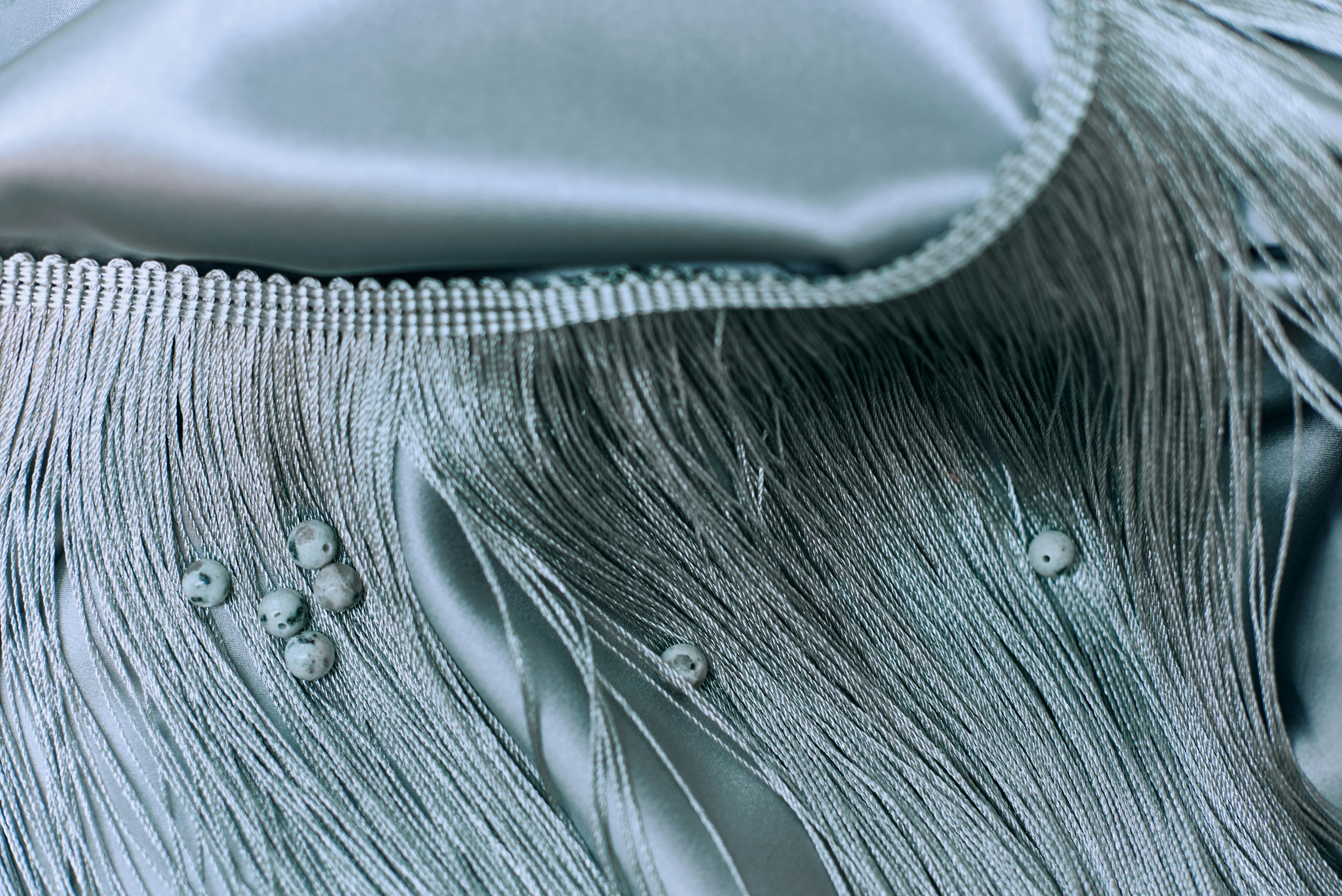 Blue fabric with decorative fringe.