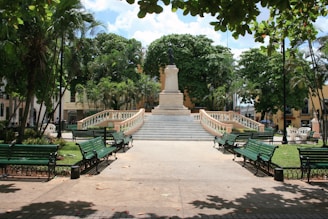 A statue and benches sit in a tranquil plaza.