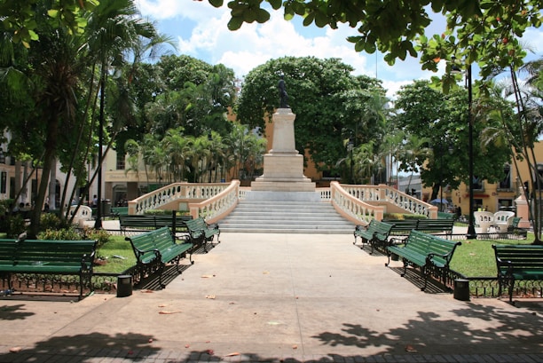 A statue and benches sit in a tranquil plaza.