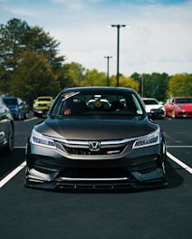 A modified honda accord is parked in a lot.